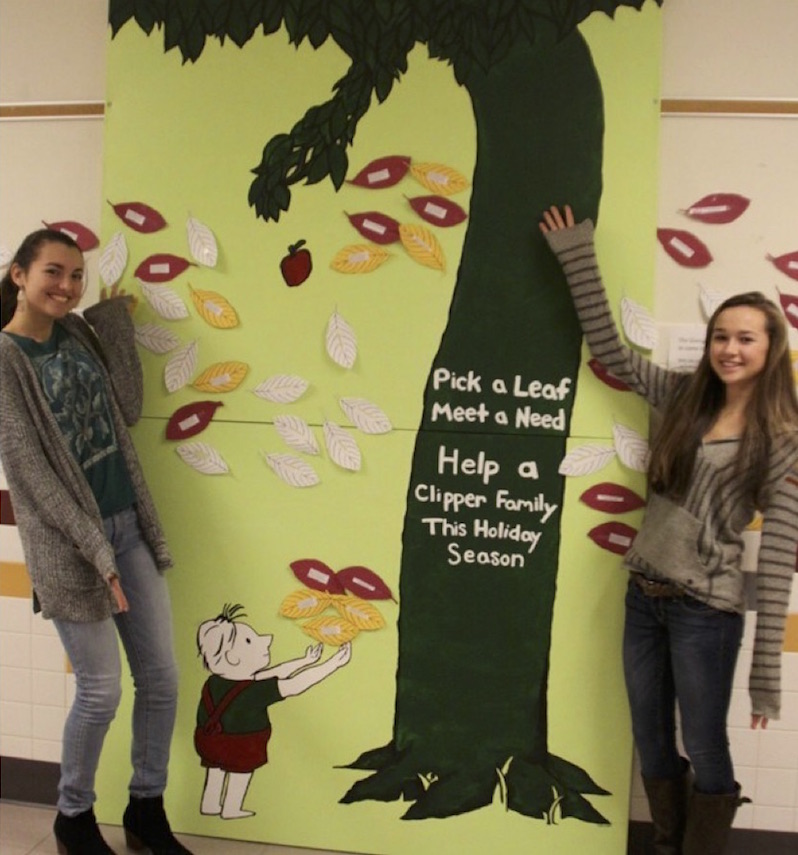 Haley Dewsnap and Lauren Marin standing with the Giving Tree displayed in main foyer at Portsmouth High School