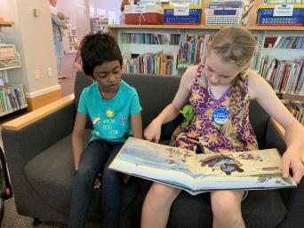 Two children reading in the library