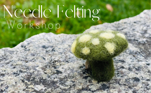 Needle felted green mushroom with cream colored dots on granite rock